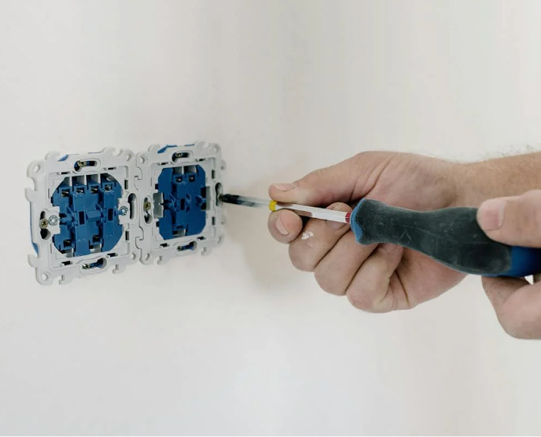 Elektriker montiert Sicherungskasten mit modernen Elektrokomponenten- Finito